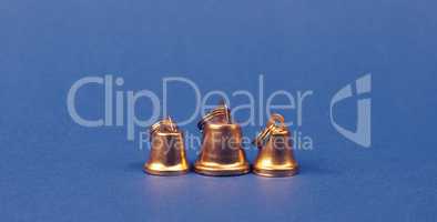 Three small golden bells on a blue background