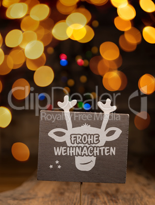 A wooden sign with a reindeer face and the German words Merry Ch