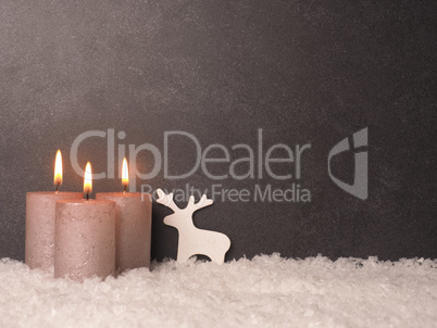 Third Advent candle burns, dark stone background