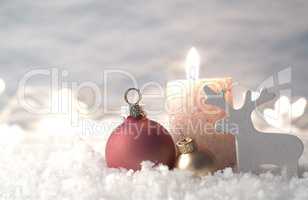 Christmas decoration in snow with candle, selective focus on gol