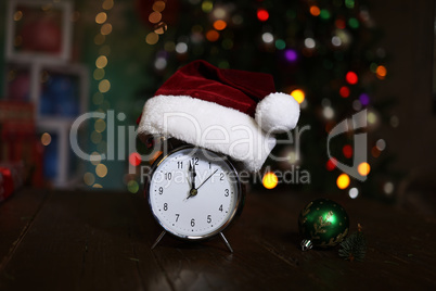 Christmas composition with an alarm clock and a Christmas tree in the background
