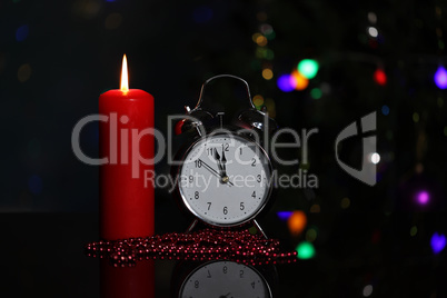 Christmas decoration with burning candles and alarm clock