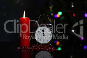 Christmas decoration with burning candles and alarm clock