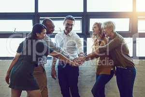 Ok guys, we got this. Shot of a group of colleagues joining their hands in solidarity at work.