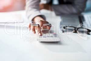 Every business move has a financial outcome. Cropped shot of a businesswoman using a calculator at her desk in a modern office.