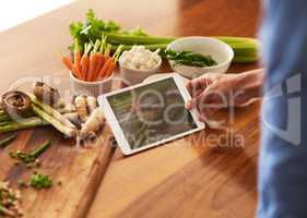 Recipes go paperless. Cropped shot of a man using a digital tablet while preparing a healthy meal at home.