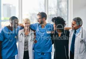Together well take care of you. Portrait of a diverse team of doctors standing together in a hospital.