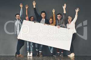 Celebrating your display. Studio shot of a diverse group of people holding up a placard against a grey background.