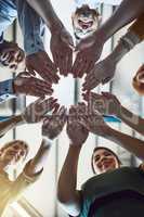 Success is in the hands of their team. Low angle shot of a group of colleagues joining their hands in solidarity at work.