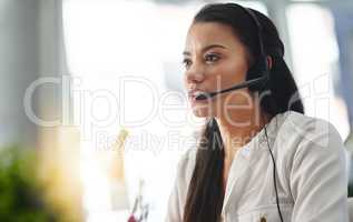 Ready to assist. Shot of a female agent working in a call centre.