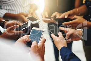 Theres no faster way to spread the word than online. Closeup shot of a group of unrecognizable businesspeople using their cellphones in synchronicity.