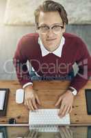 His entrepreneurial mindset will take him to the top. High angle shot of a young man using a computer at his desk in a modern office.