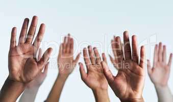 Raise your hands as one. Shot of a group of hands reaching up against a white background.