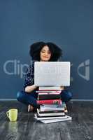 Always seek out knowledge. Studio shot of a young woman using a laptop with books stacked in front of her against a blue background.