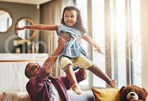 Next destination, fun. Shot of an adorable little girl and her father playing together on the sofa at home.