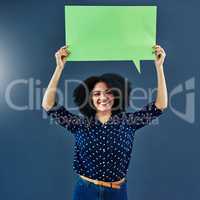 Lets start a dialogue. Studio shot of a young woman holding up a blank speech bubble against a blue background.