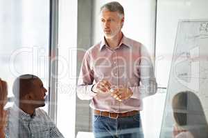 Good managers dont demand respect, they earn it. Shot of a businessman presenting his ideas to his colleagues during a meeting.
