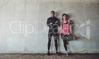 Attaining and maintaining their fitness goals together. Portrait of a sporty young couple exercising together outdoors.