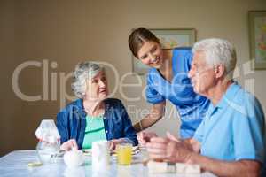 Hows breakfast. Shot of two residents and a nurse at a retirement home.