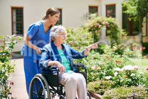 Id like to go that way. Shot of a resident and a nurse outside in the retirement home garden.