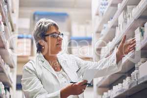 Helping patients to maintain and optimize their health. Shot of a pharmacist at work.