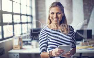 I make a living creatively. Portrait of a young designer using her digital tablet in her office.