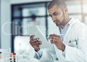 Entering data into the information system. Shot of a scientist recording his findings on a digital tablet.