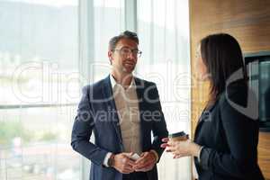 Hes always interested in what she has to say. Shot of two businesspeople talking in a corporate office.