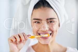 Oral hygiene comes first. Portrait of a beautiful young woman brushing her teeth in the bathroom at home.