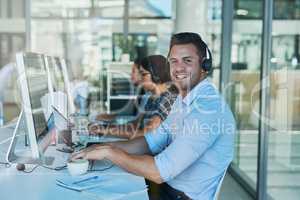 Delivering outstanding customer support day after day. Portrait of a happy and confident young man working in a call center.