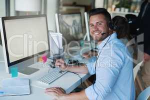 Putting a positive spin on his calls. Portrait of a happy and confident young man working in a call center.