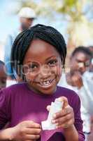 I can breathe easy now. Portrait of a little girl holding an asthma inhaler at a community outreach event.