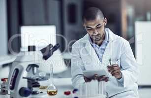 Asking questions and seeking answers. Shot of a scientist recording his findings on a digital tablet.