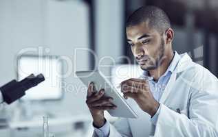 Taking advantage of electronical information. Shot of a scientist recording his findings on a digital tablet.