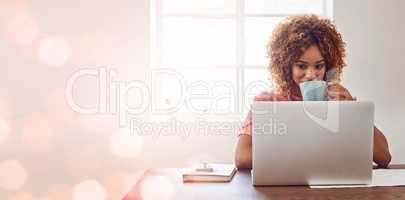 We never fail to be inspired and motivated by technology. Cropped shot of a young female designer having coffee while working on her laptop against a digitally enhanced background.