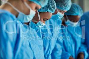 Focused in the operating theatre. Cropped shot of a group of surgeons performing a medical procedure in an operating room.