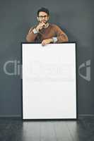 Making a big and bold statement. Studio portrait of a young man holding a blank sign against a grey background.