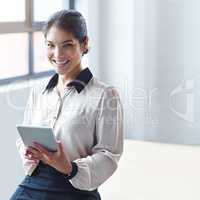 I carry my desk around with me. Portrait of a young businesswoman using a digital tablet at work.