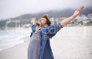 Aint life grand. Shot of a carefree young man throwing his arms back in joy.