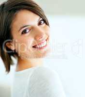 Candid and content. A beautiful woman smiling candidly at the camera - closeup.