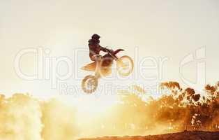 Hes way out in front. A shot of a motocross rider in midair during a race.