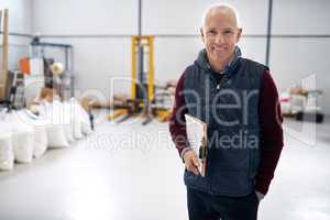 Here to do some inspecting. Portrait of a male foreman standing on the factory floor with a clipboard.