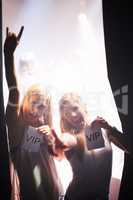 Backstage beauties. Two young women holding backstage passes at a music concert.