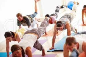 Advanced yoga techniques. A group of people working out on yoga mats.
