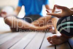 Perfect poise found through yoga. Cropped view of a two people doing yoga in the lotus position.