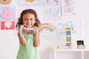 Building blocks are my favourite. Shot of a cute little girl playing with alphabet blocks.