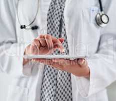 Quick and easy access to her patients. Cropped shot of an unrecognizable doctor using a digital tablet while working in a clinic.