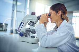 What a fascinating find we have here.... Shot of a young scientist using a microscope in a lab.