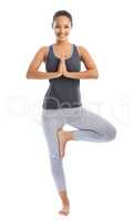 Balance and serenity. A beautiful young woman doing a yoga pose against a white background.