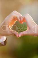 Seeing hearts. Closeup of a newlywed couple making a heart with their hands on their wedding day.